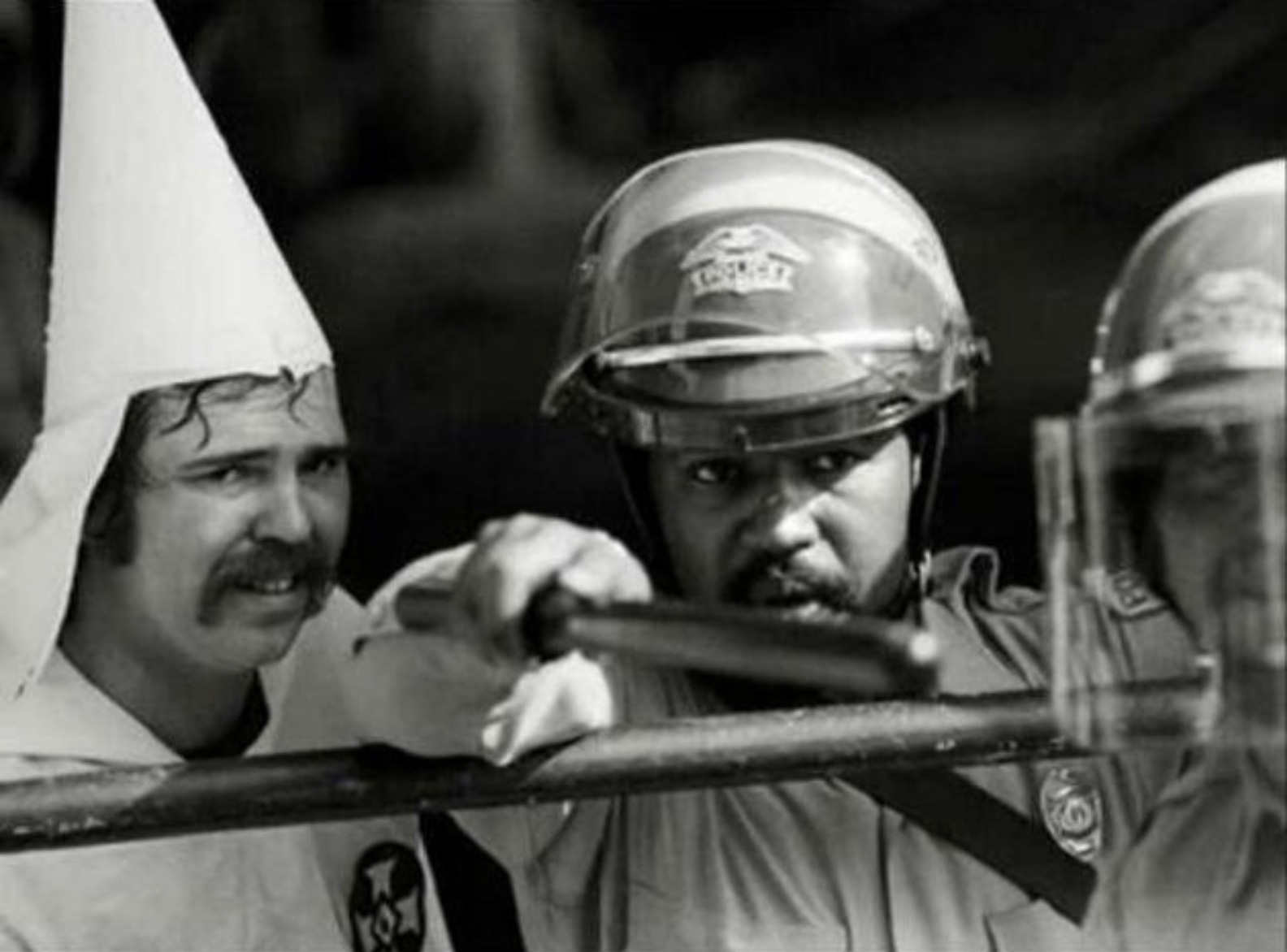 Police officers protecting a klansman from counter-protestors