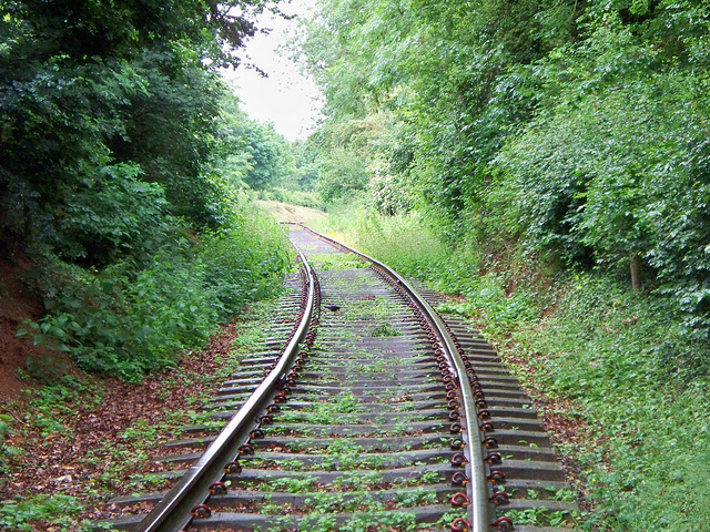 Guys picking up nickels off of railway tracks